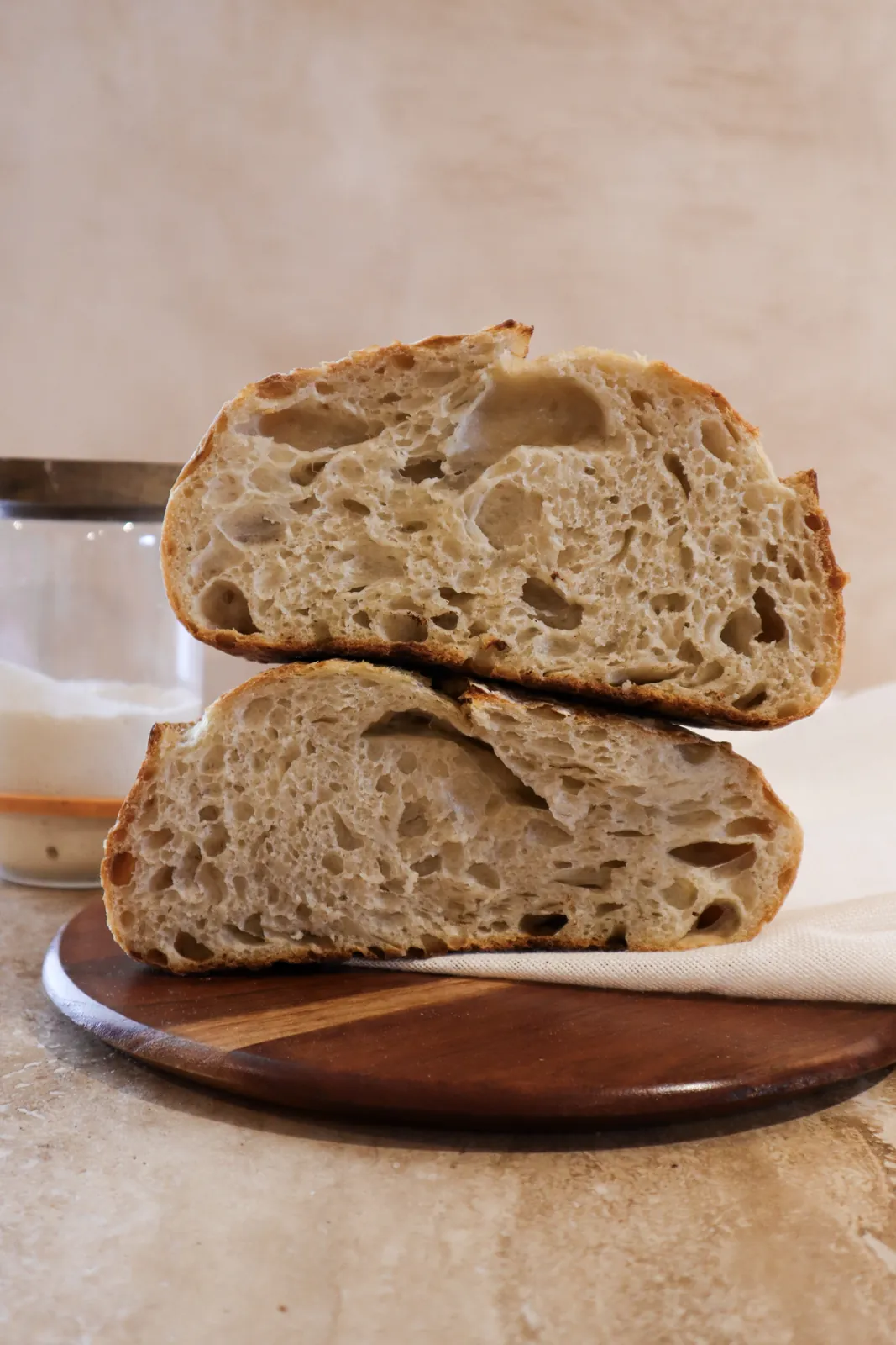 Pan de masa madre rebanado junto al frasco de fermento